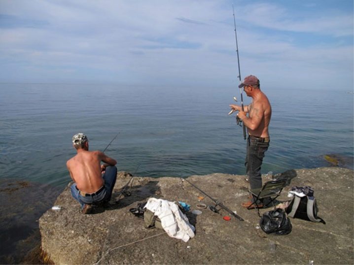 Рыбалка со спиннингом с берега реки